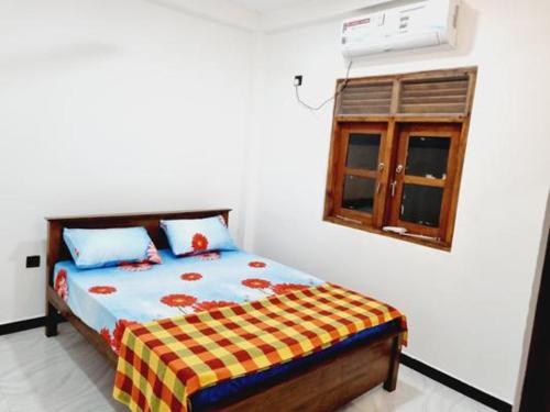 Schlafzimmer mit einem Bett und einem Fenster in der Unterkunft Hansi Villa in Piliyandala