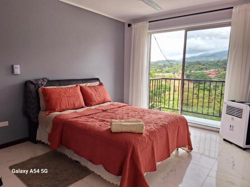 um quarto com uma cama e uma grande janela em Victoria House-Sun View Hostel em San Isidro