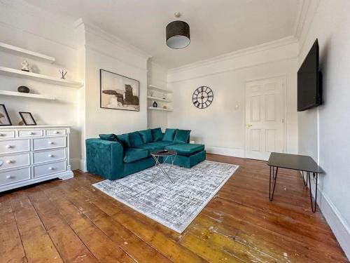 a living room with a green couch and a table at Luxe & Stylish 1 Bed Flat in London