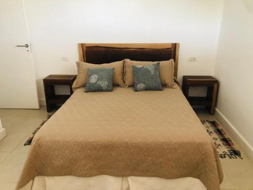 Casa Quequen في قويقوين: غرفة نوم بسرير كبير مع مواقف ليلتين