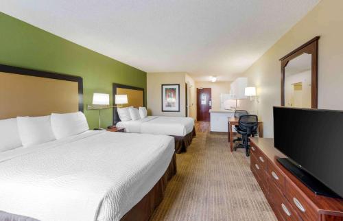 a hotel room with two beds and a flat screen tv at Extended Stay America Suites - Orange County - Huntington Beach in Huntington Beach