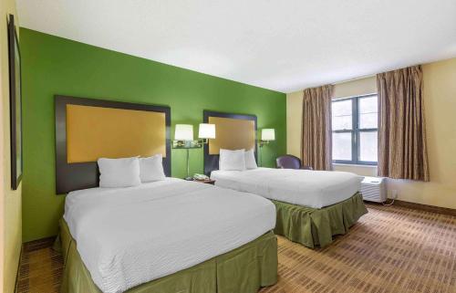two beds in a hotel room with green walls at Extended Stay America Suites - Columbus - Bradley Park in Columbus