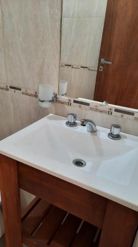 ein Badezimmer mit einem weißen Waschbecken und einem Spiegel in der Unterkunft Como en Casa in Posadas