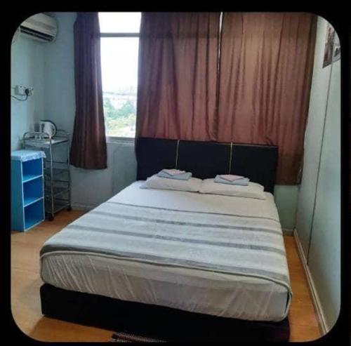 sypialnia z dużym łóżkiem i oknem w obiekcie SC Lodging House Sinsuran Complex w mieście Kota Kinabalu