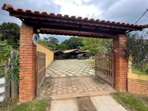 a brick archway with a gate and a fence at Sítio Olho de Boneca in Itamonte