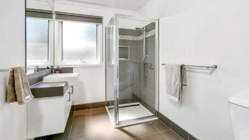 a bathroom with a glass shower and a sink at Rumah Pantai by Ready Set Stay - BYO LINEN & TOWELS in Smiths Beach