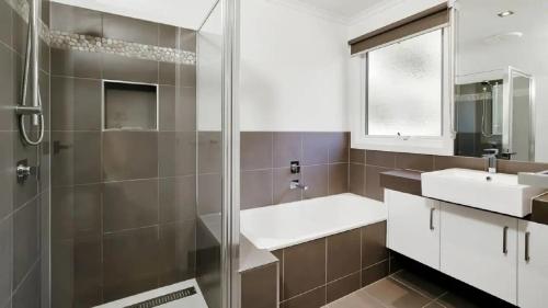 a bathroom with a glass shower and a sink at Rumah Pantai by Ready Set Stay - BYO LINEN & TOWELS in Smiths Beach