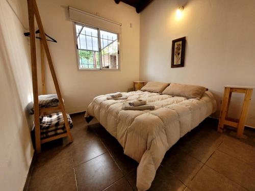 ein Schlafzimmer mit einem Bett in einem Zimmer mit einem Fenster in der Unterkunft La Algarroba in Alta Gracia