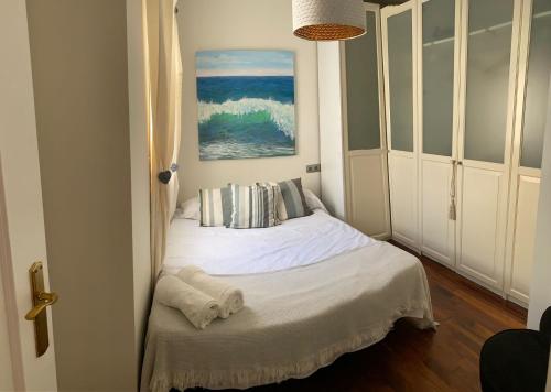 Cette petite chambre comprend un lit avec des draps blancs. dans l'établissement El Niño, à Nerja