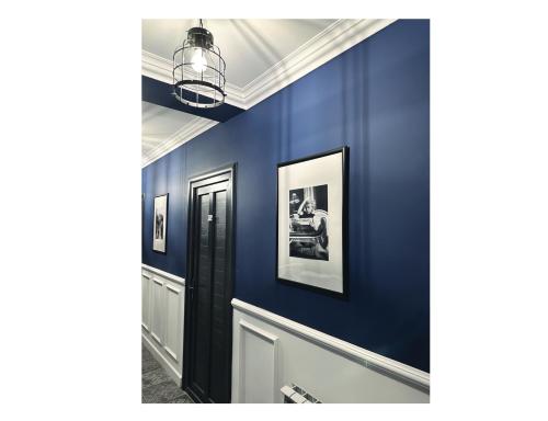 a hallway with blue walls and a pendant light at Avalon Hotel Armenia in Yerevan