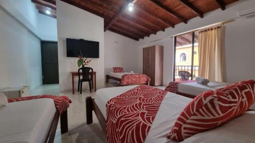 1 dormitorio con 2 camas con sábanas rojas y blancas en Hotel Bahía Yubarta en Bahía Solano
