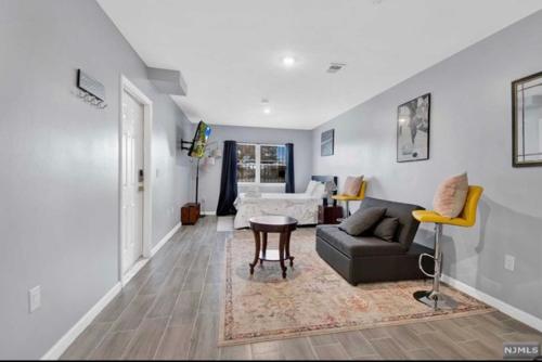een woonkamer met een bank en een tafel bij Cozy Inspired Studio Apartment in Newark