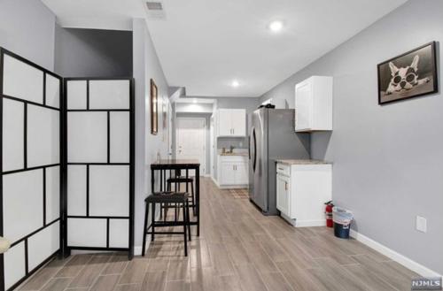 een keuken met witte kasten en een koelkast bij Cozy Inspired Studio Apartment in Newark
