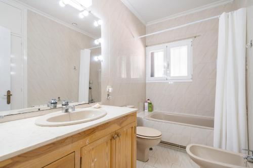 a bathroom with a sink and a toilet and a tub at Casa Rural Los Olivos de Robledo de Chavela in La Estación