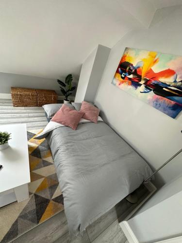 1 dormitorio con 1 cama con una pintura en la pared en DVM escape Flat 3 en Bristol