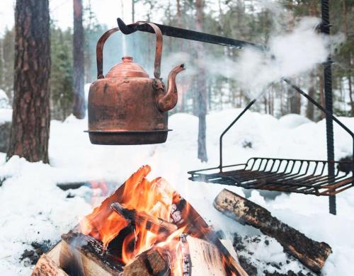 a tea kettle hanging over a camp fire at Luxury Villa BestVillas Himos in Himos