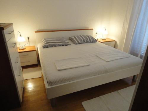 a bedroom with a white bed with two night stands at Apartment Mira in Senj