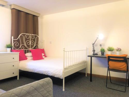 1 dormitorio con 1 cama, escritorio, 1 cama y 1 silla en Breeze Homstay en Tile Hill