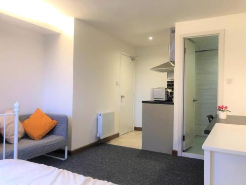 a small room with a couch and a kitchen at Breeze Homstay in Tile Hill