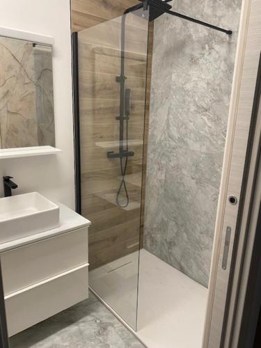 een badkamer met een glazen douche en een wastafel bij Sandra's House in Izola