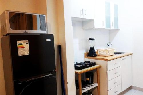 a kitchen with a black refrigerator with a microwave at LOVENEST in Lima