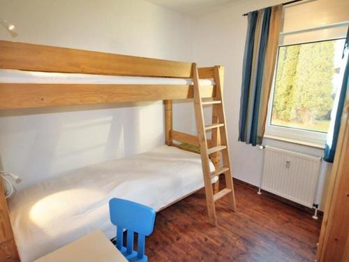 キュールングスボルンにあるReriker-Strasse-26-EG-rechts-ruhig-Lage-9978のベッドルーム1室(二段ベッド2台、青い椅子付)
