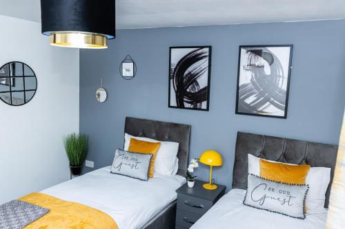 Duas camas num quarto com paredes azuis em TD Carsh Wolverhampton - Luxurious 2 Bed House - Sleeps 6 - Perfect for Long Stay Workers - Leisure - Families em Wolverhampton