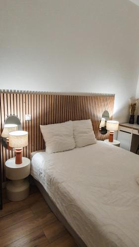 - une chambre avec un lit blanc et deux lampes dans l'établissement Appartement au calme T3 RDC - Quartier de France, à Vichy