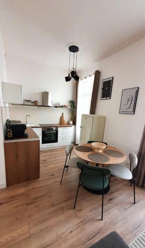 une cuisine avec une table et des chaises dans une pièce dans l'établissement Appartement au calme T3 RDC - Quartier de France, à Vichy