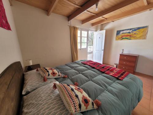 Un dormitorio con una cama grande con almohadas. en Hospedaje Rural Casa de Felix, en San Pedro de Atacama