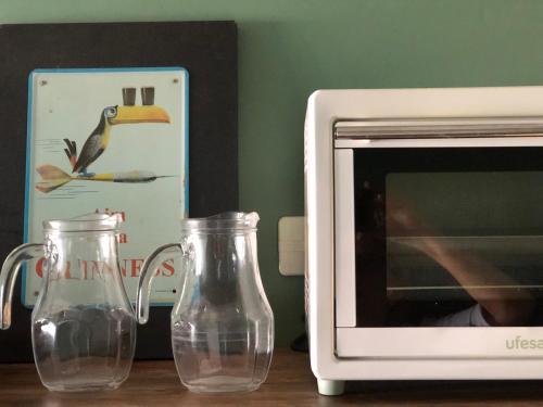two glass vases sitting next to a microwave at Best location ! Apt privado 2 hab con AC Completamente equipado en Asuncion in Asuncion