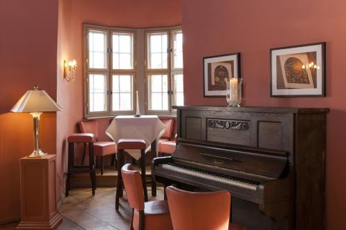 a room with a piano and a table and chairs at Wyndham Garden Quedlinburg Stadtschloss in Quedlinburg