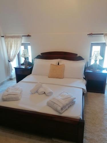 a bedroom with a bed with towels on it at Mani Fort Charabos in Stavríon