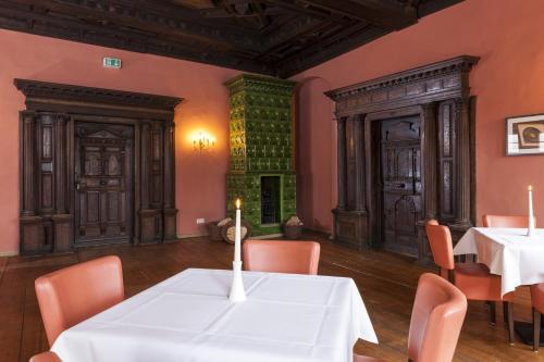 a dining room with tables and chairs and a fireplace at Wyndham Garden Quedlinburg Stadtschloss in Quedlinburg