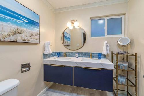 een badkamer met een wastafel en een spiegel bij Seq Parks-House with Hot Tub Fire Pit Koi Pond Outdoor Kitchen in Visalia