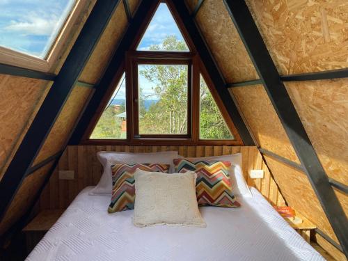 Cama en habitación pequeña con ventana en ALTEA triángulo con jacuzzi, Santa Elena, en Medellín