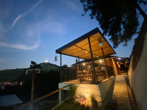 a small building with a balcony at night at Itaipava Cama e Café in Itaipava