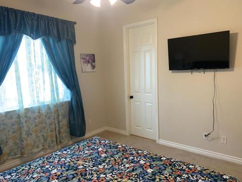 a bedroom with a bed and a flat screen tv at LuxHome Suites in Mansion in Riverside