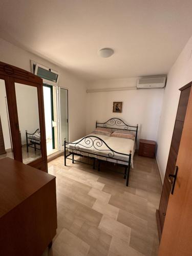 ein Schlafzimmer mit einem Bett in der Mitte eines Zimmers in der Unterkunft Perla Marina in Capitolo