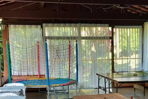 a room with a net and a table and chairs at Casa com churrasqueira piscina privativa em São Pedro da Serra - Perto de Lumiar in Nova Friburgo
