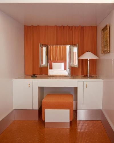 une coiffeuse avec un tabouret orange et un miroir dans l'établissement Pied A Terre Arts et Métiers, à Paris