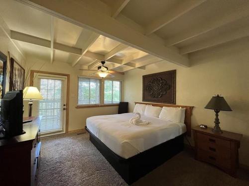 ein Schlafzimmer mit einem großen weißen Bett und einem TV in der Unterkunft Mountain Harbor Forest View Lodge cottage in Mount Ida