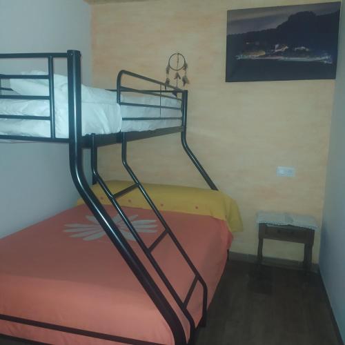 a bunk bed in a room with a table and a stool at Casa Haza San Luis in Riópar