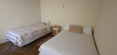 a bedroom with two beds and a night stand at Tower Suites in Paraguarí