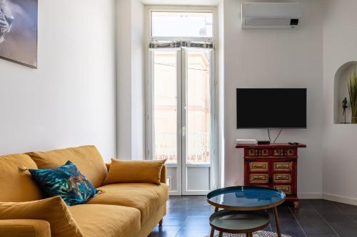 un salon avec un canapé et une télévision dans l'établissement Charming Apartment In The Center Of Cannes, à Cannes