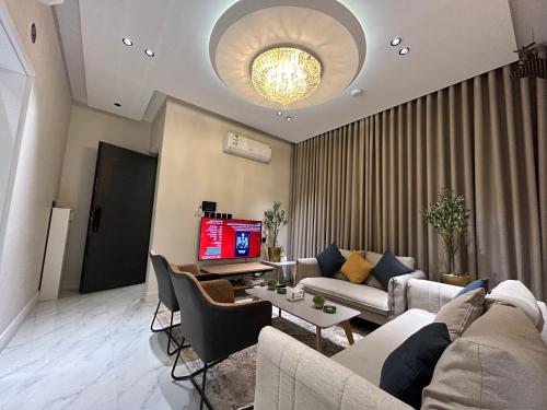 a living room with a couch and a tv at شقة فاخرة ٣ غرف نوم وصالة بدخول ذاتي ١١ in Riyadh