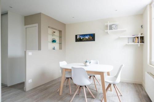 une salle à manger avec une table blanche et des chaises blanches dans l'établissement Great Apt Near The Beach Pornichet, à Pornichet
