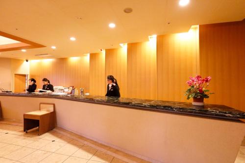 two women sitting at a bar in a restaurant at Plaza Inn Mizusawa in Oshu