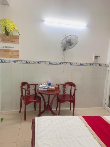 a room with a table and two chairs and a fan at Happy 1 Hotel Binh Duong in Bến Cát