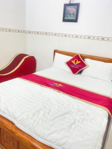 a bed with a red and white blanket on it at Happy 1 Hotel Binh Duong in Bến Cát